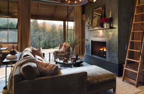Cozy mountain retreat with rustic wooden beams, plush furnishings, and a roaring fireplace.