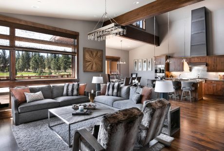 Spacious open-concept living area with modern furniture, wood beams, and expansive windows.