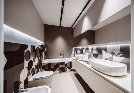 Modern bathroom with geometric patterns, clean lines, and sleek white fixtures.