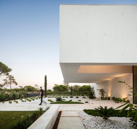 A modern architectural marvel with a sleek, minimalist design and beautifully landscaped garden.