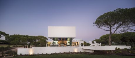 A striking modern building with sleek, angular design set amidst lush greenery.