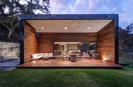 Stunning modern outdoor living space with warm wood accents, large deck, and stone walls.