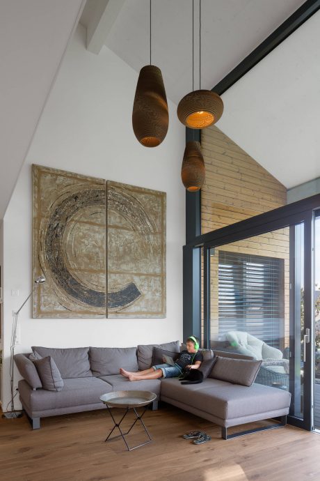 A modern interior with unique pendant lighting, brick accent wall, and large abstract artwork.