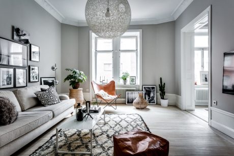 Cozy Scandinavian-style living room with neutral tones, plush furniture, and modern lighting fixture.