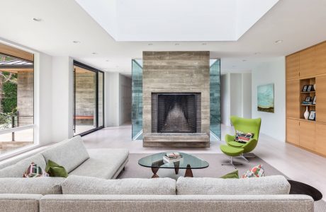 Spacious living room with modern fireplace, glass walls, and contemporary furnishings.