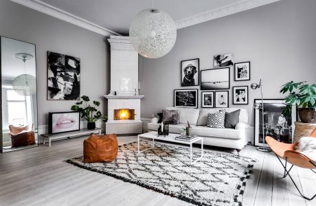 A cozy, modern living room with a fireplace, artwork, and eclectic furnishings.