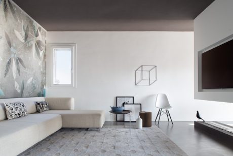 Modern minimalist living room with sleek furniture, geometric decor, and a striking abstract mural.