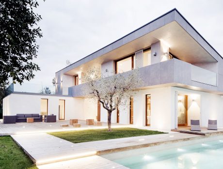 Sleek, modern house with expansive windows, minimalist decor, and a pool in the backyard.