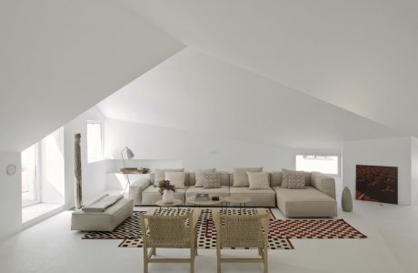 A spacious, minimalist living room with natural light, modern furniture, and eclectic accents.