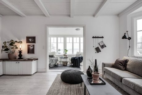 Bright, airy living room with rustic beams, large windows, and cozy furnishings.