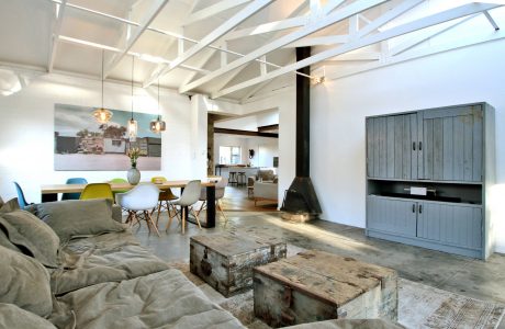 Spacious open-concept living area with exposed beams, rustic furnishings, and eclectic decor.