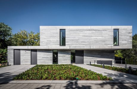 A modern, minimalist building with a striking concrete facade, clean lines, and minimal landscaping.