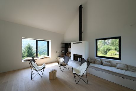 A modern, minimalist living space with large windows offering scenic mountain views.