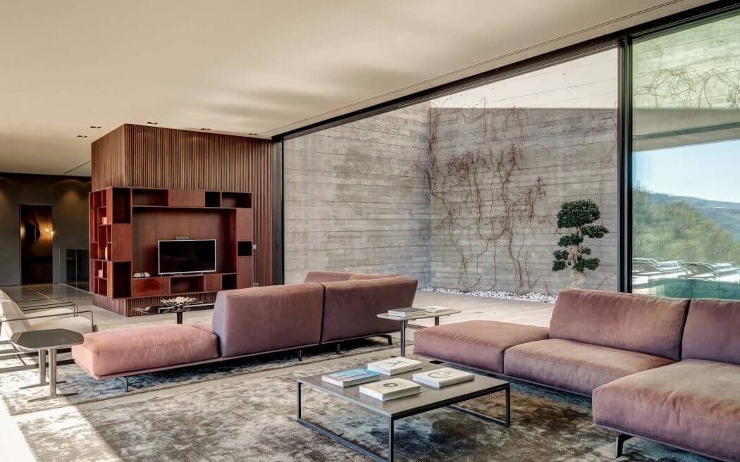 Luxurious modern living room with sleek wood-paneled wall, glass window, and plush seating.