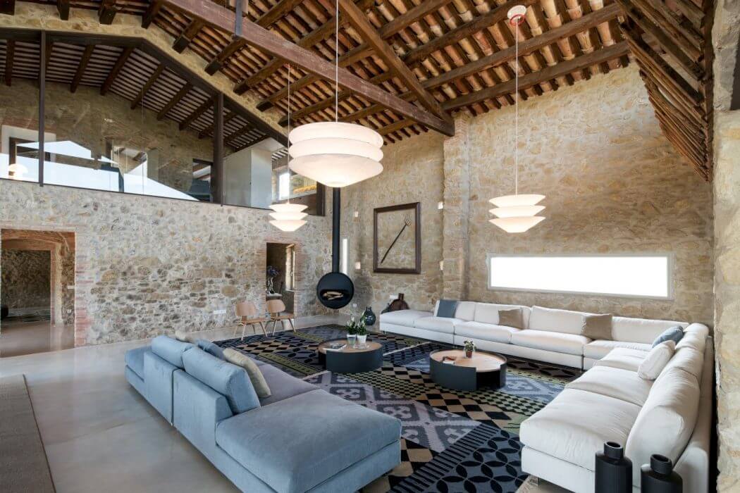 Rustic stone walls, exposed wooden beams, and modern furnishings create a warm, inviting space.
