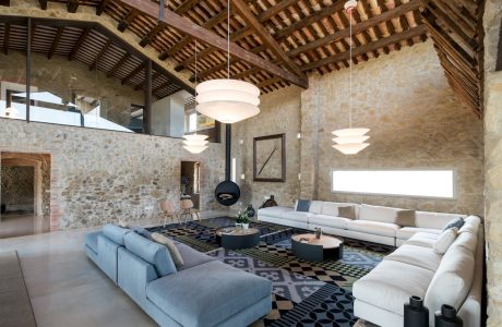 Rustic stone walls, exposed wooden beams, and modern furnishings create a warm, inviting space.