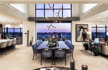 Sleek modern dining room with floor-to-ceiling windows showcasing a cityscape view.