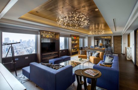 Lavish room with wooden paneling, chandeliers, and panoramic city views.