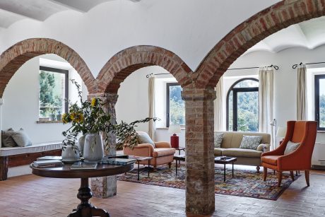 Elegant brick arches frame a cozy, rustic living space with plush seating and decor.