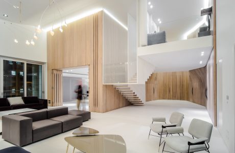 Minimalist contemporary interior with wood accents, floating staircase, and modern furniture.