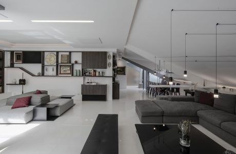 Spacious open-plan living area with minimalist gray furnishings and modern decor elements.