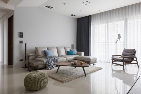 A spacious and modern living room with a plush sectional sofa, low coffee table, and cozy armchair.