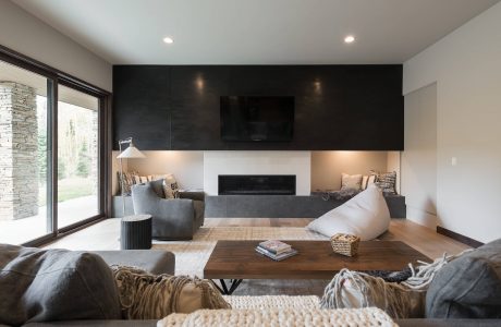 Modern living room with sleek black accent wall, wood coffee table, and cozy seating.