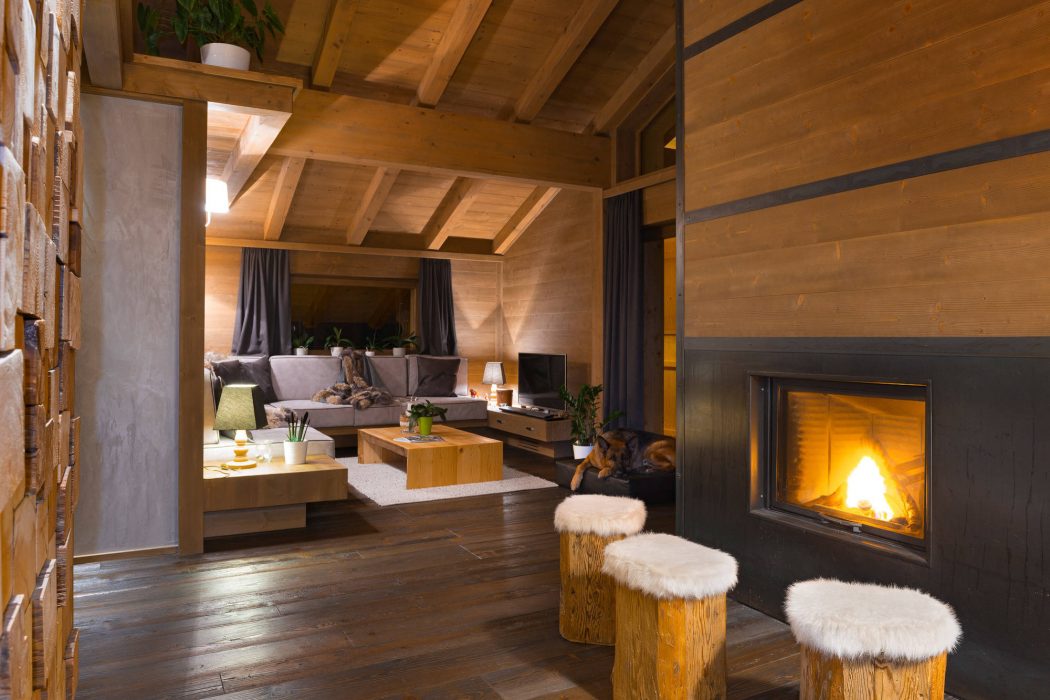 Cozy mountain lodge interior with wood beams, fireplace, and rustic furniture.