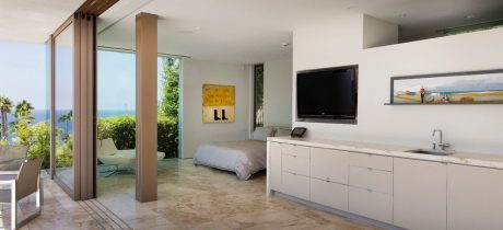 Spacious modern bedroom with floor-to-ceiling windows, minimalist decor, and sleek built-in furniture.