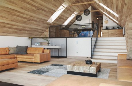 A cozy loft with a vaulted wooden ceiling, stairs, and a comfortable living area.