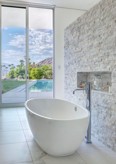 Luxurious bathroom with freestanding tub, modern fixtures, and panoramic mountain views.