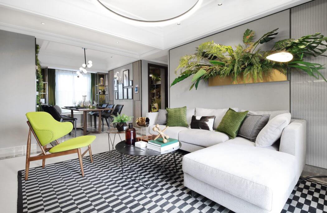Modern, stylish living room with striking black-and-white flooring, vibrant green accents, and lush plant decor.