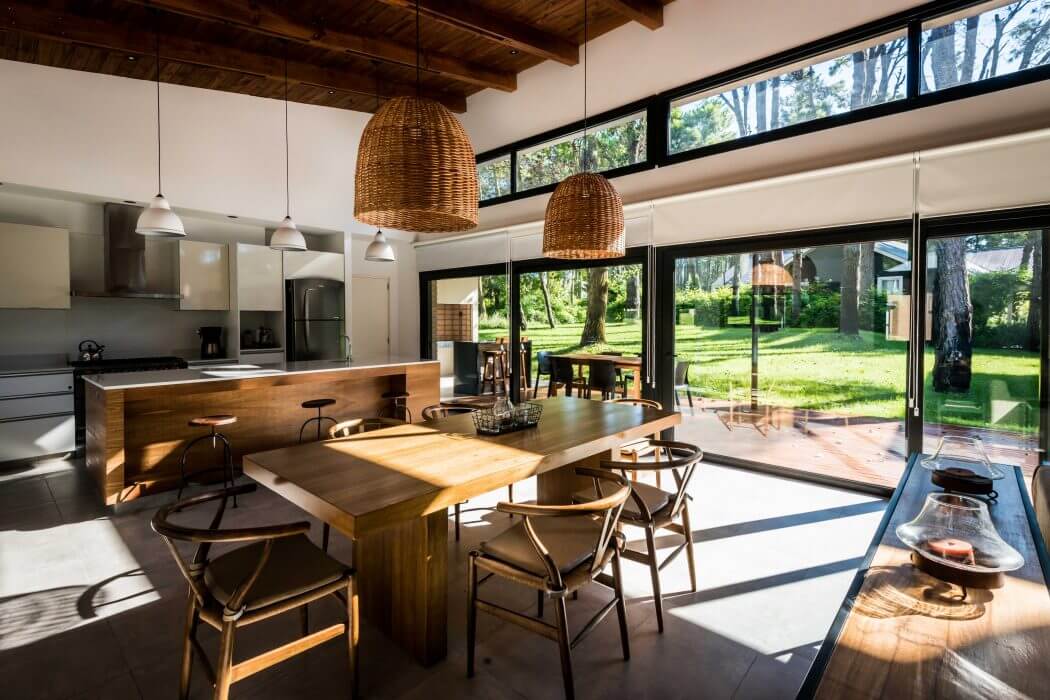 Cozy dining space with wood-beamed ceiling, woven pendant lights, and floor-to-ceiling windows.