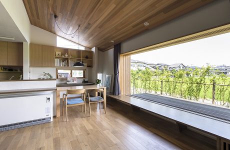 Spacious open-concept kitchen-living area with wooden ceiling and large window offering scenic views.