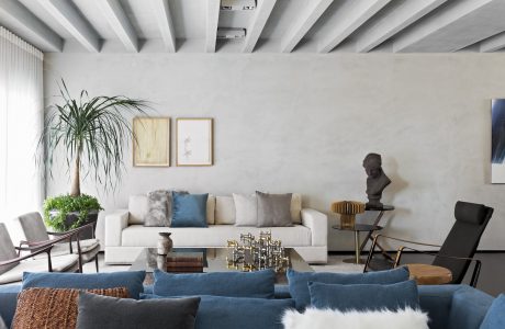 Minimalist living space with high ceilings, neutral tones, and modern furniture.