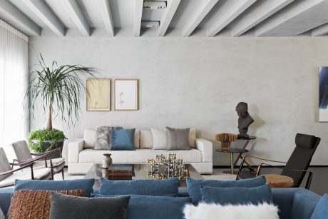 Minimalist living space with high ceilings, neutral tones, and modern furniture.