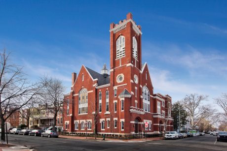 Majestic brick building with ornate architectural details and a towering clock tower.