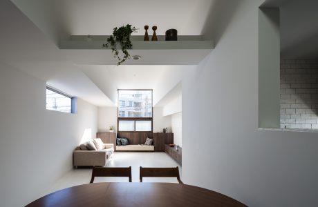 Minimalist living room with built-in seating, wood accents, and shelving for decor.