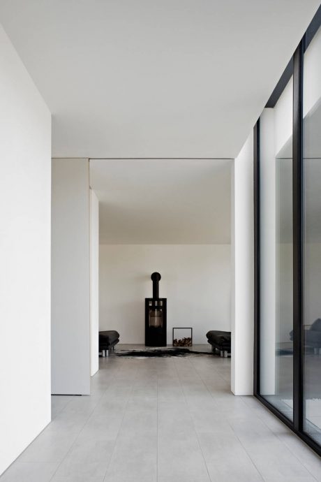 Minimalist white interior with sleek black architectural details and recessed lighting.