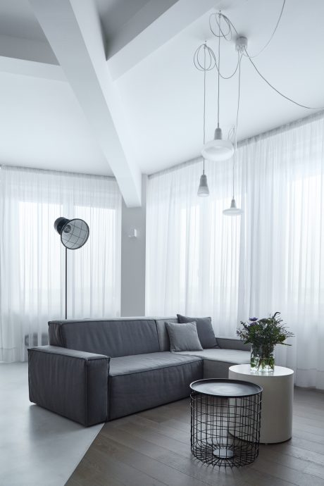 Sleek, minimalist living room with modern lighting fixtures and a stylish sectional sofa.