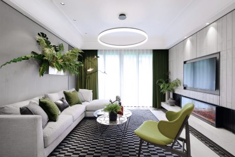 Modern living room with geometric patterned flooring, circular lighting, and potted plants.