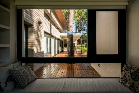 A cozy and modern living space with a large window showcasing a lush, forested exterior.
