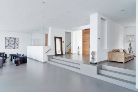 Minimalist interior design with clean lines, neutral colors, and built-in steps leading to another level.