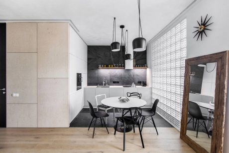 Minimalist kitchen and dining area with sleek cabinetry, pendant lights, and eclectic furnishings.
