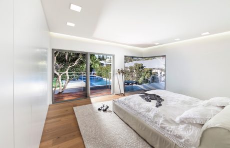 Spacious bedroom with large sliding glass doors offering scenic outdoor views and pool.