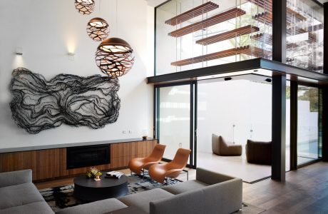 Sleek modern living space with floor-to-ceiling windows, custom lighting, and sculptural decor.