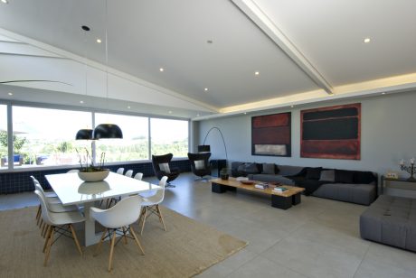 Modern open-plan living space with minimalist decor, large windows, and contemporary furniture.