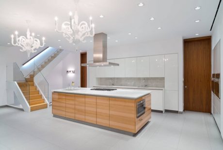 Sleek, open-concept kitchen with wood-paneled island, pendant lights, and minimalist design.