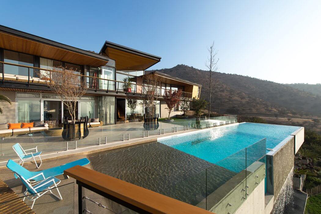 Luxurious modern home with an infinity pool overlooking a scenic mountainous landscape.