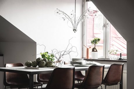 Sophisticated dining area with dark furniture, artistic wall decor, and natural plants.